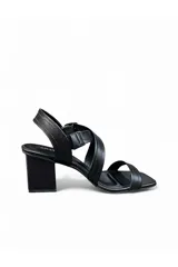Sandalias de taco cuadrado y punta cuadrada color negro, con tiras cruzadas en el empeine y cierre de hebilla en el tobillo.