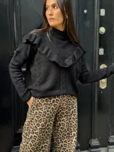 Sweater color beige de tejido de punto con ochos, cuello alto y volados en el escote.