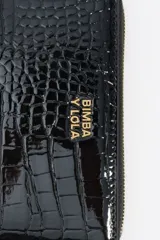 Billetera rectangular de estructura rígida con acabado brillante y textura efecto cocodrilo. Cuenta con cierre de cremallera perimetral, tirador de tejido y logo metálico dorado en el frente.