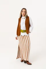 Falda larga tejida a rayas verticales color beige y blanco, con pretina elástica y tajos laterales.