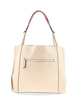Cartera tipo shopper amplia de cuero graneado color crema, de moldería clásica y formato rectangular. Presenta pespuntes decorativos a contratono en los laterales y asas al hombro con correas de cuero. Incluye detalle de logo metálico frontal.