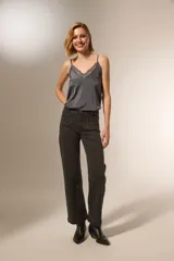 Pantalon de corte recto y tiro medio, confeccionado en denim color gris oscuro. Presenta bolsillos delanteros decorados con tachas metálicas pequeñas en los bordes y costuras reforzadas.
