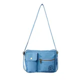 Bolso bandolera Rip Curl Cruisin Utility de tela denim celeste con correa larga regulable. Tiene un bolsillo frontal con botón a presión, un bolsillo frontal con cierre y logo de la marca bordado.