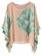 Blusa de corte asimétrico y holgado, color camel, con estampado de hojas en tonos verdes y cuello redondo.