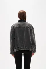 Campera de jean con lavado gris desgastado, cuello camisero en pana negra, cierre frontal con botones y bolsillos laterales amplios.