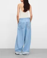 Pantalón baggy de denim de algodón orgánico y reciclado, color celeste claro, con pliegues frontales, bolsillos laterales y dobladillo vuelto en la parte inferior.