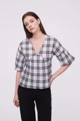 Blusa de algodón con estampado a cuadros, cuello en V, corte holgado y mangas cortas abullonadas con frunces.