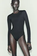 Body de manga larga confeccionado en mezcla de poliamida, con cuello redondo y cierre inferior con botones a presión.