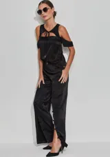 Pantalón negro de satén con corte recto y cintura alta. Presenta una abertura lateral con botones revestidos y cierre trasero invisible.