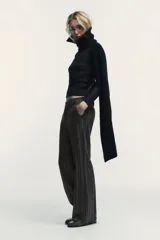 Pantalón de tiro alto con diseño de cuadros, corte recto y cintura con trabillas. Cuenta con bolsillos laterales, falsos bolsillos traseros de vivo y cierre frontal con cremallera, botón y ganchos metálicos.
