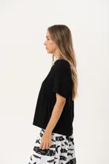 Blusa negra de corte holgado con mangas cortas.