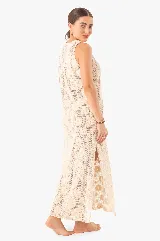 Vestido largo de punto color crema con diseño calado de flores, escote redondo y aberturas laterales.