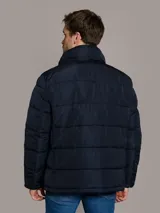 Campera puffer azul marino de Calvin Klein, de diseño acolchado con cuello alto y cierre frontal de cremallera. Incluye bolsillos laterales con cierre y chaleco interior desmontable.