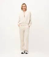 Campera bomber deportiva de mujer color beige, confeccionada en modal con cierre frontal por cremallera, cuello medio y bolsillos. Presenta mangas largas con puños elásticos y elástico en la cintura.
