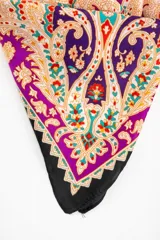 Bandana cuadrada con estampado paisley en tonos violeta, fucsia, negro y beige.