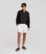 Camisa de corte relajado confeccionada en cambraia de lino puro. Presenta cuello inglés, cierre frontal con botones y mangas largas.