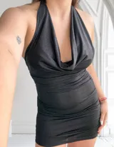 Vestido corto negro con brillos, escote halter y espalda descubierta.