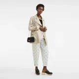 Clutch de cuero negro Longchamp modelo Le Roseau con correa de cadena plateada.