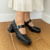 Zapato estilo Mary Jane de cuero vacuno con acabado brillante, punta cuadrada y taco bloque. Cuenta con una tira ajustable sobre el empeine con hebilla metálica.