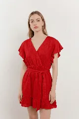 Vestido corto de lino blanco con escote cruzado en V, mangas cortas con vuelo y cintura elastizada con lazo para ajustar la silueta.