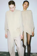 Jeans de tiro alto, corte ancho y pierna recta, color beige claro con efecto lavado. Presenta trabillas en la cintura, bolsillos delanteros y traseros, y cierre frontal con cremallera y botón.