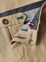 Pantalón chino de corte slim y pierna recta, color beige, confeccionado en sarga de algodón elástico.