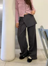 Pantalón sastrero gris a rayas verticales, de tiro alto con bolsillos y pretina trasera elastizada.