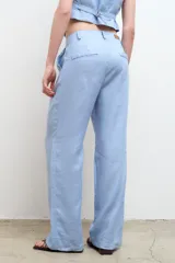 Pantalón de vestir color beige, de corte recto y tiro alto, confeccionado en lino 100% con bolsillos laterales.