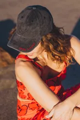 Gorra tipo baseball de color gris oscuro con efecto lavado. Presenta un corazón bordado en la parte frontal y la frase 'MON AMOUR' bordada en hilo rojo sobre la visera.