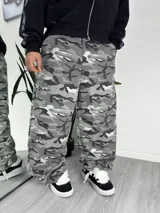 Pantalón baggy de corte holgado con estampado de camuflaje en tonos grises, blancos y negros.