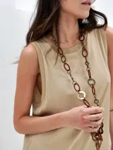 Vestido negro largo de tela satinada, sin mangas y con cuello redondo.