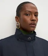 Campera bomber de denim azul oscuro, con cuello alto, cierre frontal con botones a presión ocultos, mangas largas con puños ajustables y diseño de largo corto.