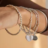 Pulsera de cadena tipo rolo en plata 925, con un dije colgante en forma de corazón liso apto para grabado.