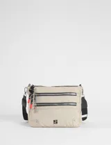 Bandolera color beige con múltiples compartimentos frontales con cierre metálico, correa ajustable negra y detalle de tiradores de cuerda con terminales rojos.