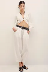 Pantalón babucha negro de lino, de corte holgado estilo barrel con pinzas en la cintura y bolsillos laterales.