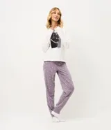 Pijama largo de dos piezas compuesto por una remera de manga larga color blanco con cuello redondo y estampa frontal de un gato con collar de perlas, y un pantalón color lila con estampado de lunares blancos, cintura elástica con cordón y puños ajustados en los tobillos.