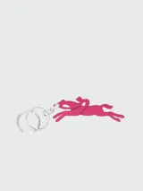 Llavero Longchamp Le Pliage con dije de cuero rosa en forma de jinete a caballo y dos aros metálicos plateados con el nombre de la marca grabado.