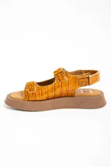 Sandalias de cuero color caramelo con textura efecto cocodrilo, suela chunky marrón y tiras ajustables con velcro.