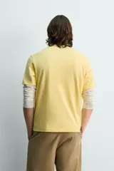 Camiseta de corte regular fit confeccionada en tejido de algodón, con diseño de rayas horizontales en color naranja y blanco, cuello redondo y manga corta.
