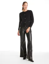 Cardigan de punto con textura tipo waffle, color blanco, con escote a la base, cierre frontal con botones metálicos dorados y detalles desflecados en la tapeta y los bolsillos simulados.