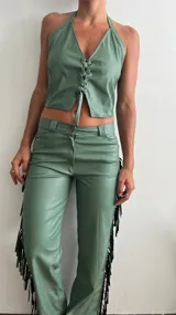 Pantalón de cuero sintético color verde safari, corte recto, con flecos largos en los laterales.