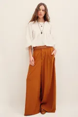 Pantalón ancho negro de tiro medio, con bolsillos laterales y pinzas frontales.