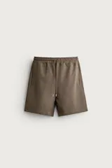 Bermuda estilo jogger de ajuste relajado, confeccionada en tejido interlock de algodón. Cuenta con cintura elástica ajustable con cordón, bolsillos frontales de vivo y diseño liso.