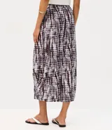 Pantalón aladín de cintura alta confeccionado en viscosa texturizada con estampado tie-dye en tonos oscuros. Presenta un corte amplio con volumen en las piernas y bajos afinados.