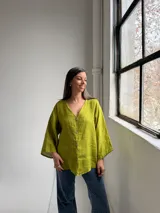 Camisa de lino color verde pistacho, de corte holgado, con escote en V y cierre frontal con botones.