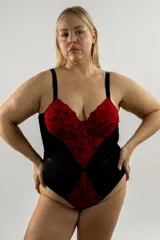 Body de base negra con apliques de puntilla roja elastizada en el busto, el centro y la entrepierna. Posee aros, copas forradas, tirantes elásticos regulables y cierre con broches en la entrepierna.
