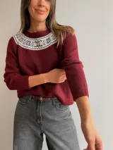 Sweater de punto color bordó con cuello redondo y diseño de guarda decorativa estilo nórdico en la zona del escote en tonos claros. Presenta mangas largas con puños acanalados y un corte holgado.