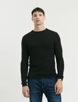 Sweater de punto con textura tipo waffle, color negro, de corte clásico con cuello redondo y mangas largas.