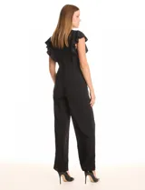 Enterito negro de crepe liviano con cuello redondo, mangas cortas con volados, corte en la cintura, bolsillos funcionales y cierre invisible en la espalda. La parte inferior es de pierna ancha tipo palazzo.