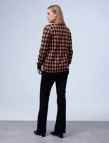 Cardigan tejido con escote en V y abertura central con botones. Diseño con rombos color marrón y negro.